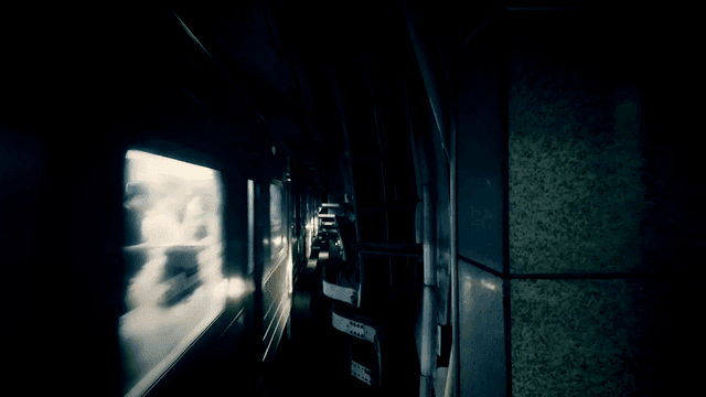 Subway train moving through a dim tunnel