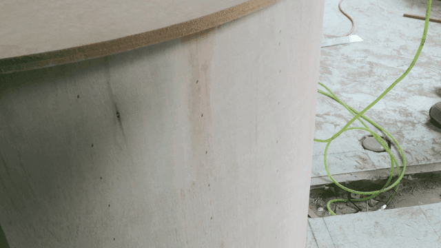 Wooden structure with green cable on floor