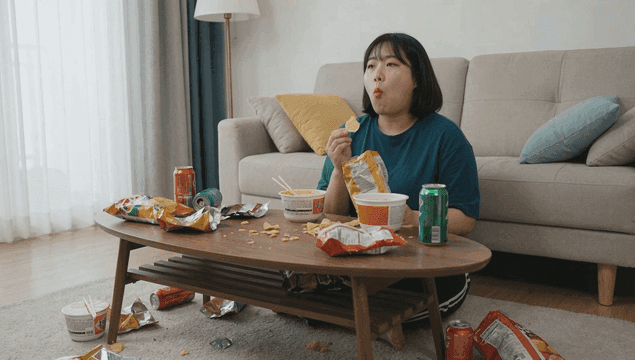 Woman eating snacks in cozy living room