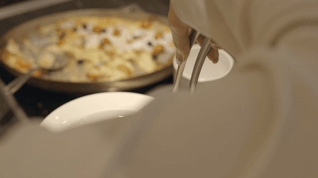 Pasta being served onto a plate