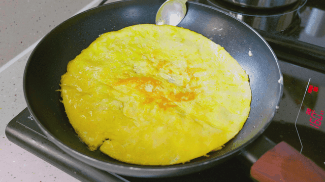 팬에서 뒤집어 지고있는 계란 지단