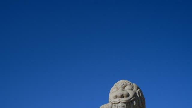 Stone Guardian Lion Against Blue Sky