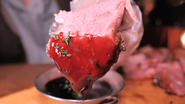 Turkey dipped in sauce on wooden cutting board