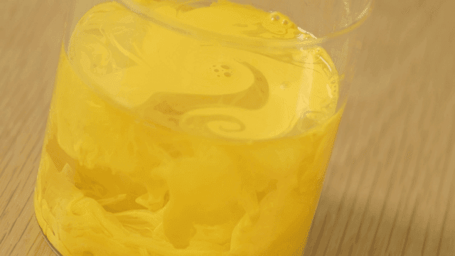 Yellow dye swirling in a glass of water