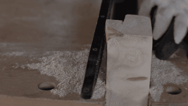 목공줄로 나무를 섬세하게 다듬는 장갑 낀 손