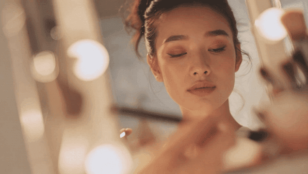 브러시로 메이크업하는 여성