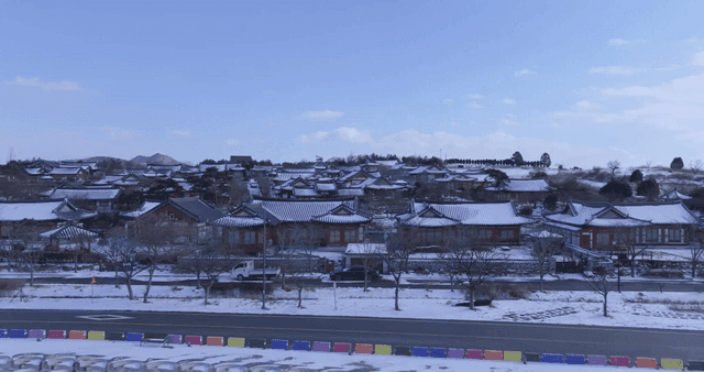 Snow-covered traditional Korean village by road