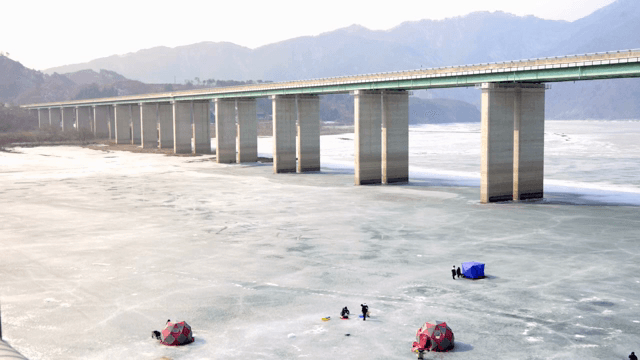 텐트와 다리가 있는 얼어붙은 호수