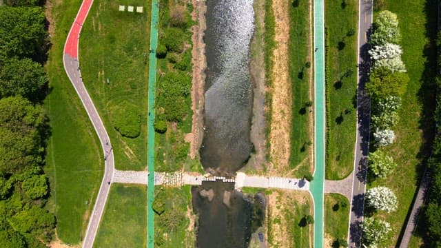 Park and walking trails by the stream surrounded by greenery