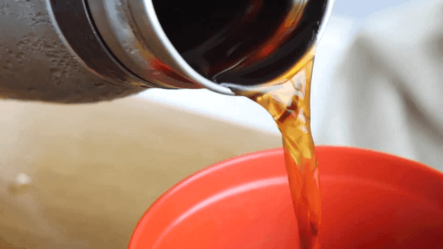 빨간 그릇에 모밀 육수를 따르는 장면