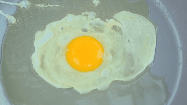 프라이팬에 계란을 깨는 장면