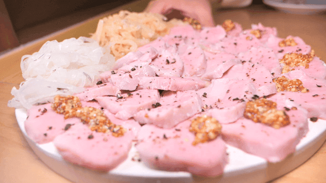 Pink sous vide sirloin slices served with onion garnish