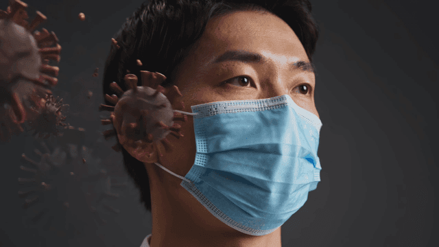 Person wearing a mask with virus particles