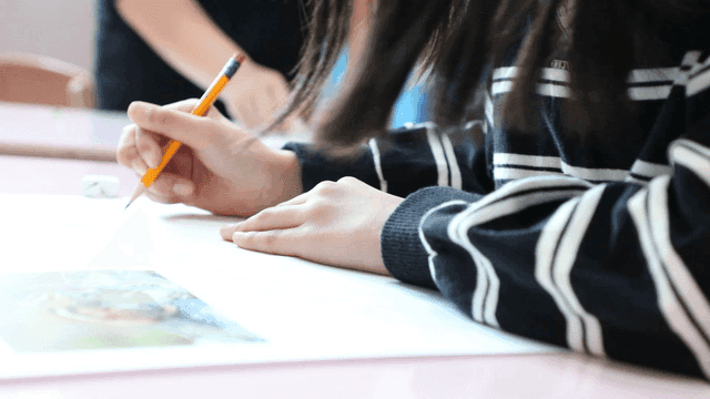 Student writing with focus and concentration