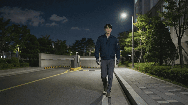 Young security guard patrolling quiet apartment complex at night
