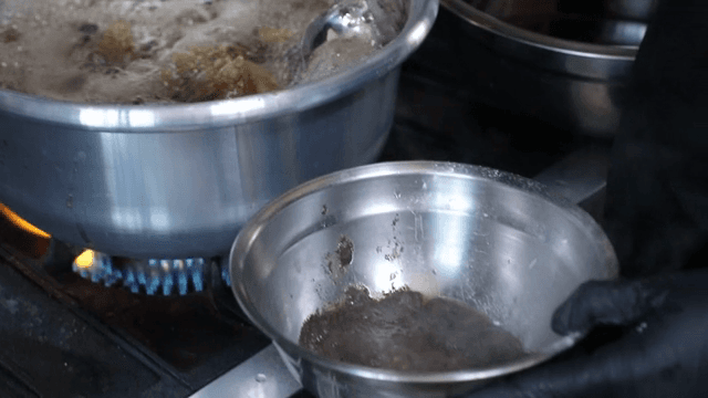 끓는 냄비에서 불순물을 걷어내는 장면