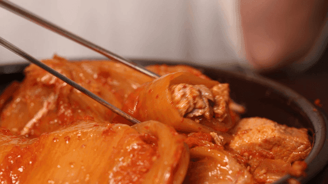 Person who wraps kimchi around meat in kimchi stew before eating it.