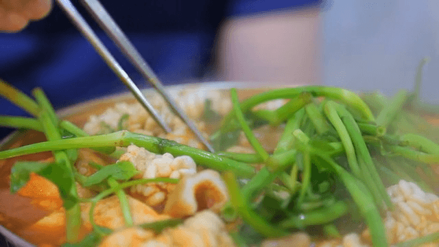 Picking up cod in the spicy fish stew with chopsticks