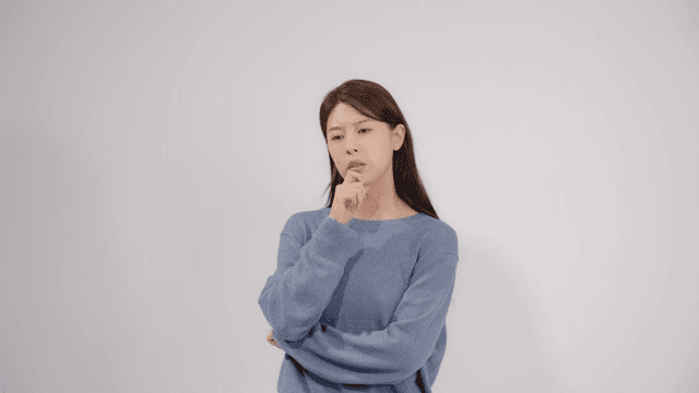 손가락을 턱에 괴고 깊은 생각에 잠긴 여성