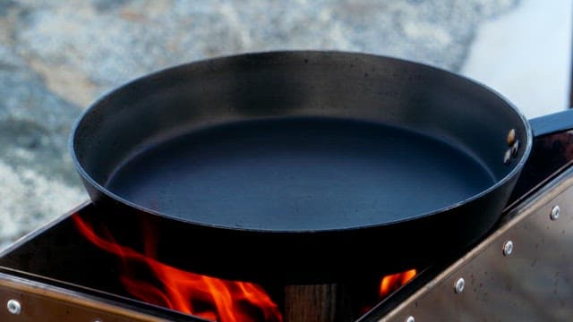 Fresh lamb being cooked in a frying pan on the portable stove