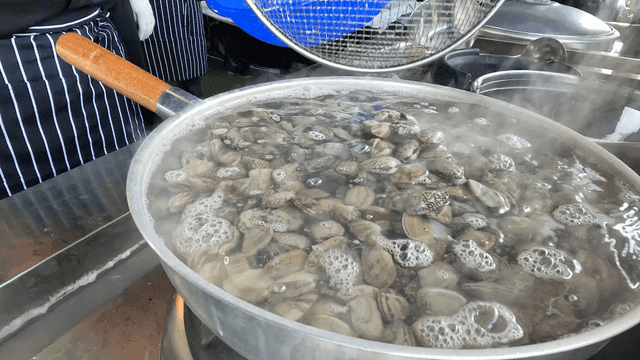 Clams being boiled in a large pot