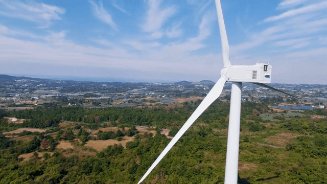 넓은 녹색 풍경 속 풍력 터빈