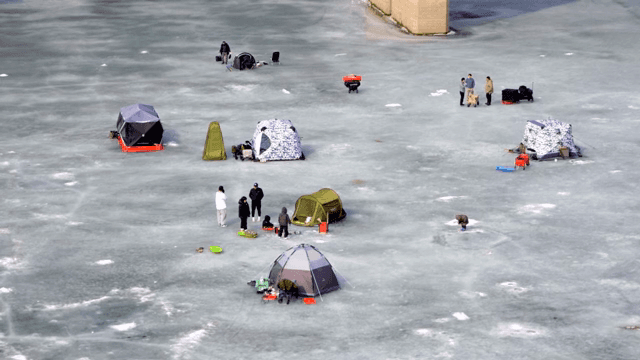 얼어붙은 빙판에서 빙어 낚시하는 사람들