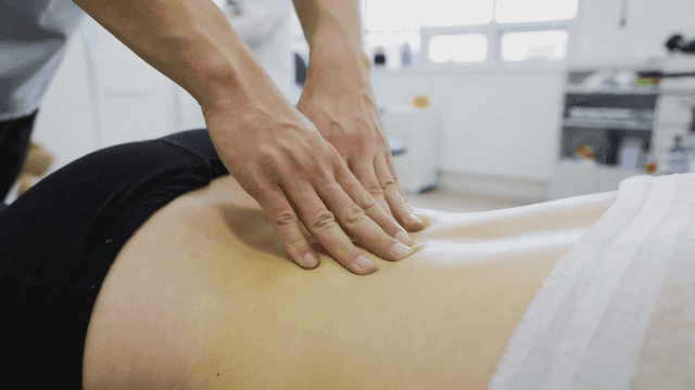 Massage therapist massaging lower back