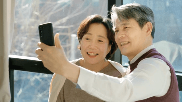 Elderly couple taking a selfie by the window