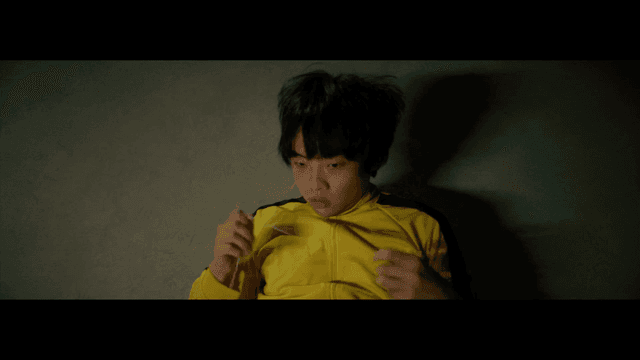 노란 트랙수트를 입고 바닥에 누워 있는 사람