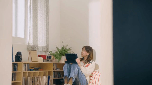 Woman using tablet in cozy room and looking out window