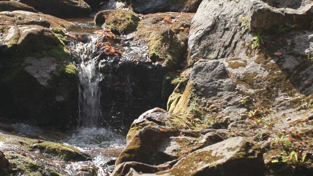 Refreshing waterfall among the sun-drenched rocks