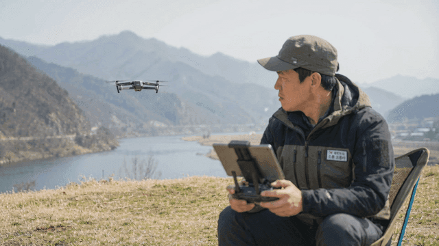 Man operating drone by river