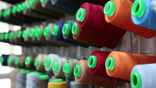 다양한 색깔의 실이 걸려있는 수선가게의 벽