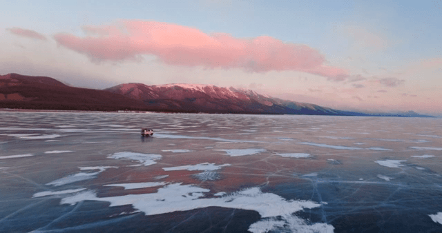 해질녘 얼어붙은 호수 위를 지나가는 차량
