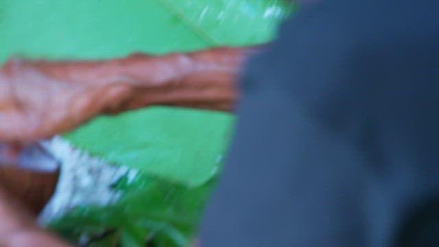 바나나 잎 위에서 코코넛을 갈고 있는 손