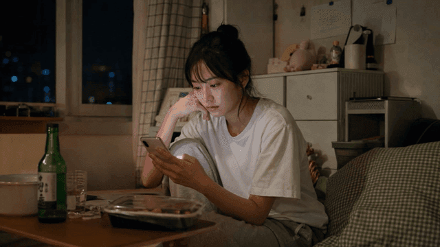 Woman looking at smartphone in her room at night