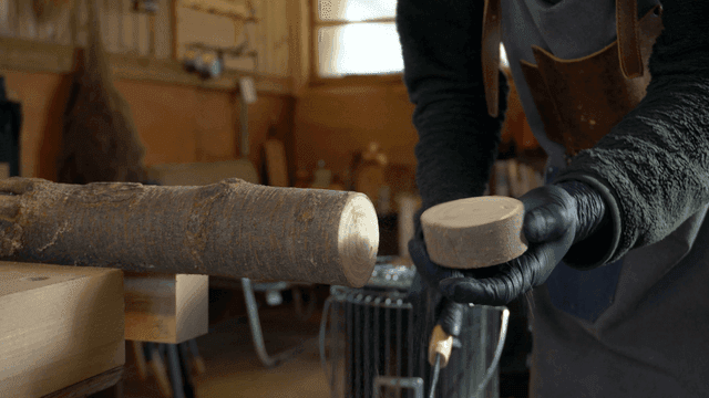 작업실에서 통나무를 자르는 장인