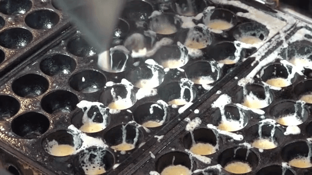 타코야끼 팬에 반죽을 붓는 장면