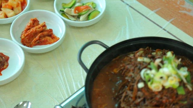 Plate of pork backbone stew topped with sweet potato stem salad