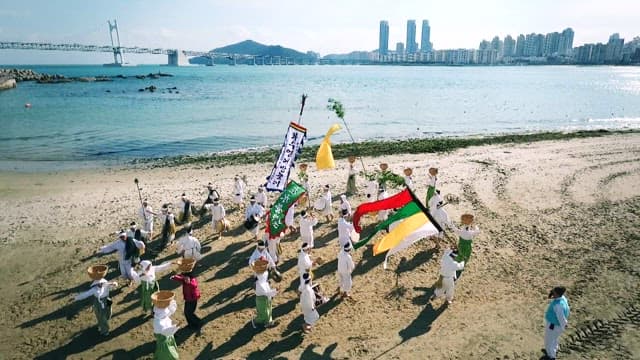 Traditional dance performance on the beach with flags