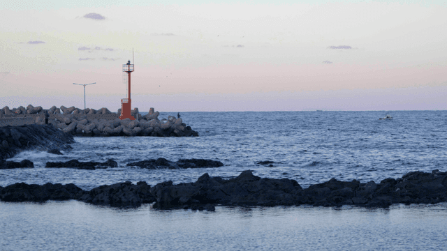 Calm sea with lighthouse in evening