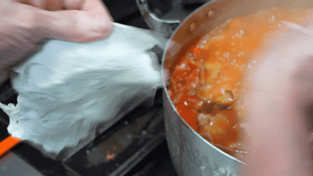 Hands kneading spicy dumpling dough next to pot