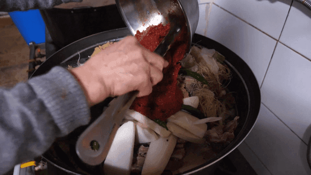 한국식 고깃국에 매운 양념을 넣는 장면