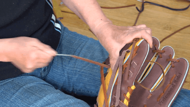 Craftsman threading lace into baseball glove