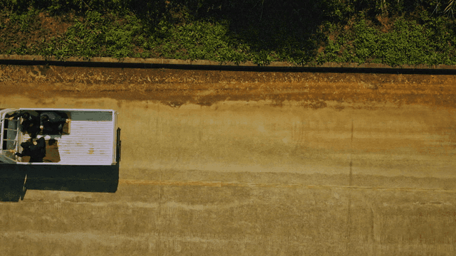 트럭 적재함에 타고있는 세 사람