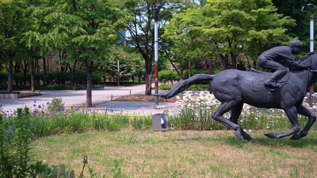 Statues of jockeys racing on horses in a park