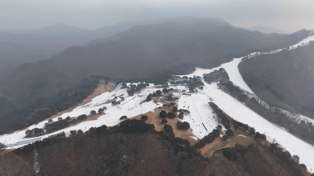 Mountain with cable car and snow-covered ski resort