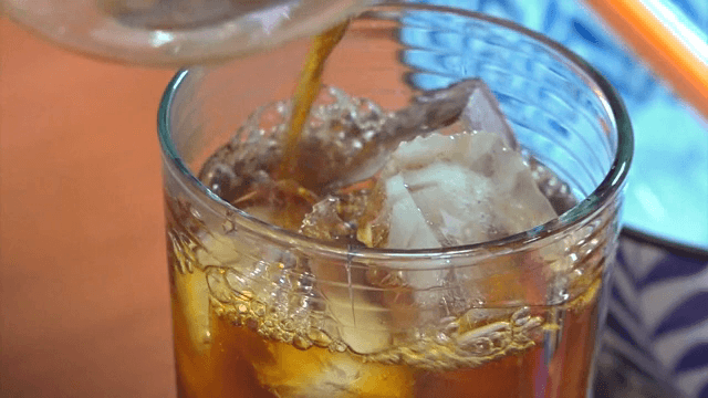 얼음이 든 유리잔에 커피를 붓는 장면