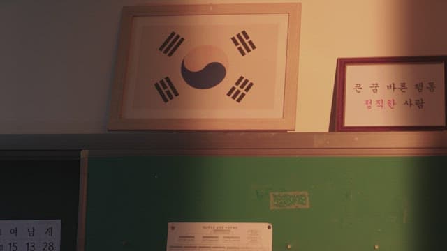 따뜻한 햇살이 비추는 교실 벽에 걸린 태극기